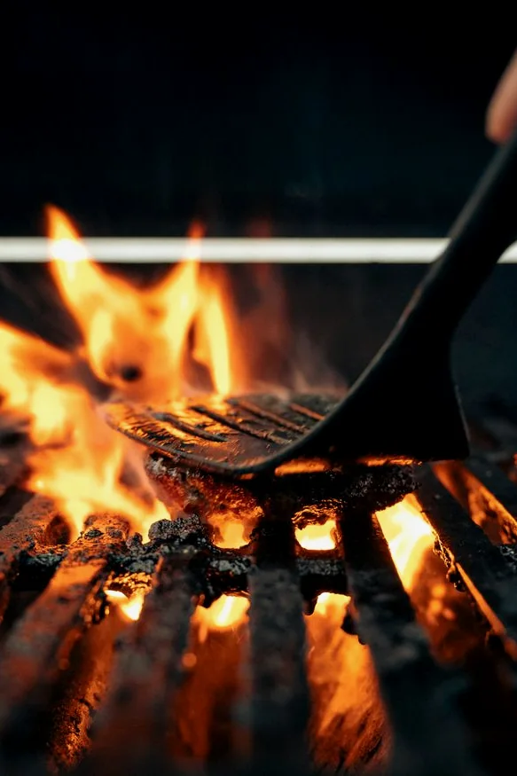Plancha a 300°C con hamburguesas ahumándose